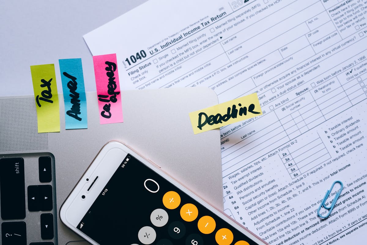 Calculatrice, documents fiscaux et notes posés sur un bureau