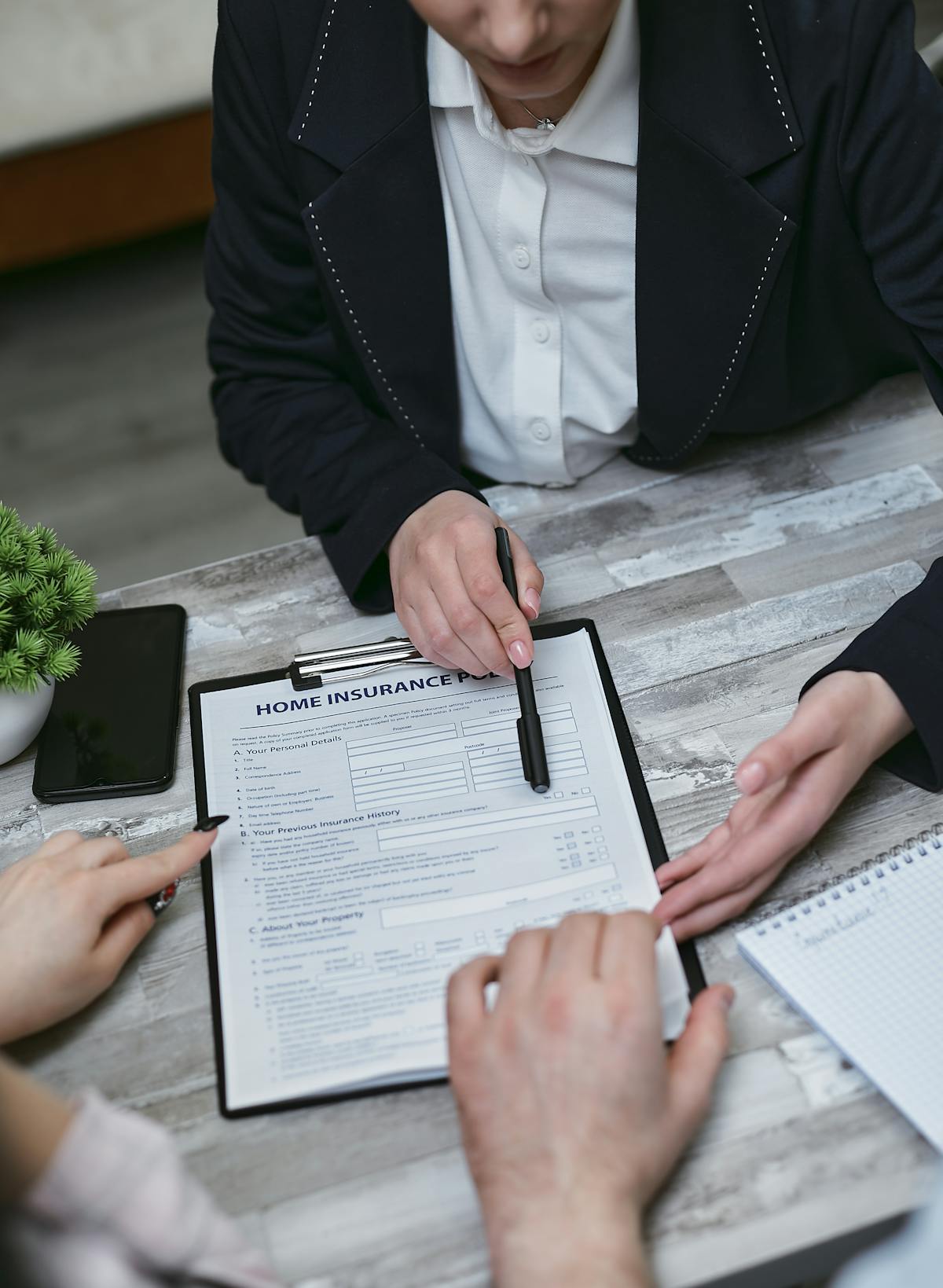 Conseiller en assurance expliquant un contrat à des clients autour d'une table