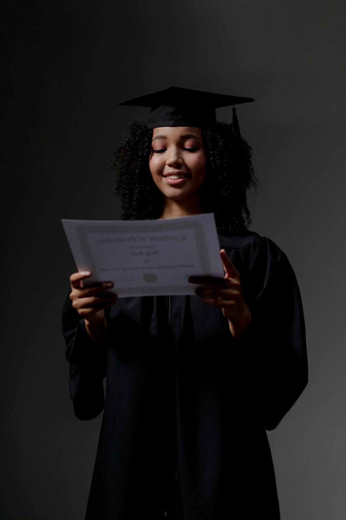 Jeune diplômée en toque et toge tenant un certificat