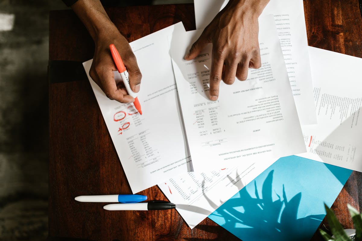Mains surlignant des documents financiers sur un bureau