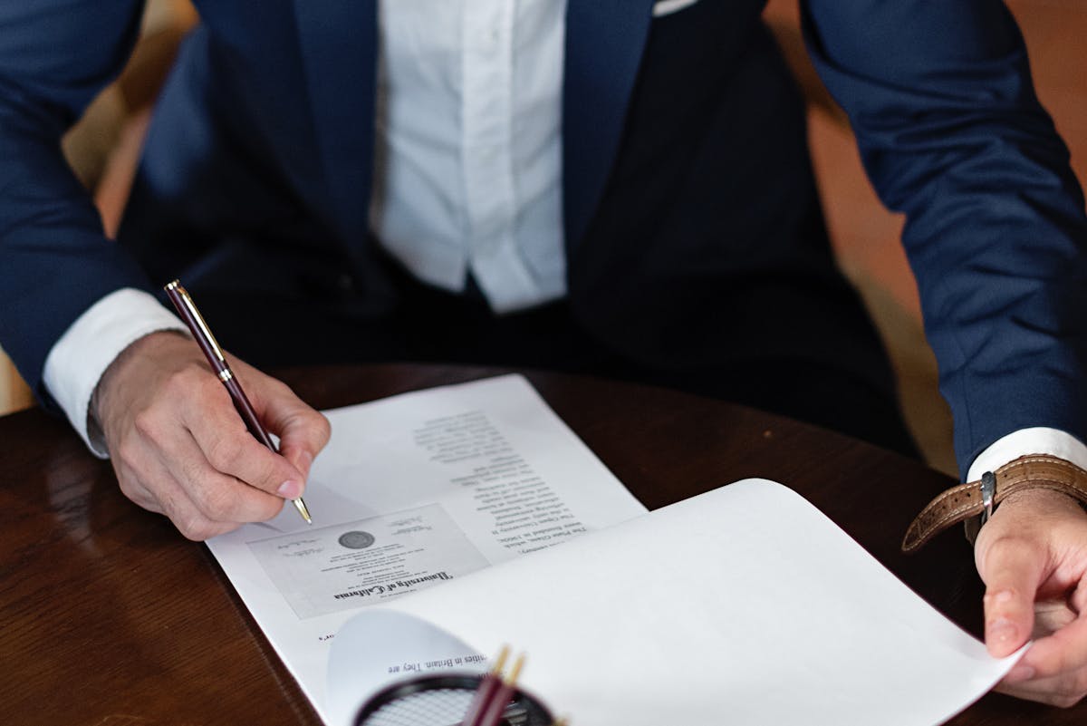 Personne signant des documents légaux à un bureau dans un bureau